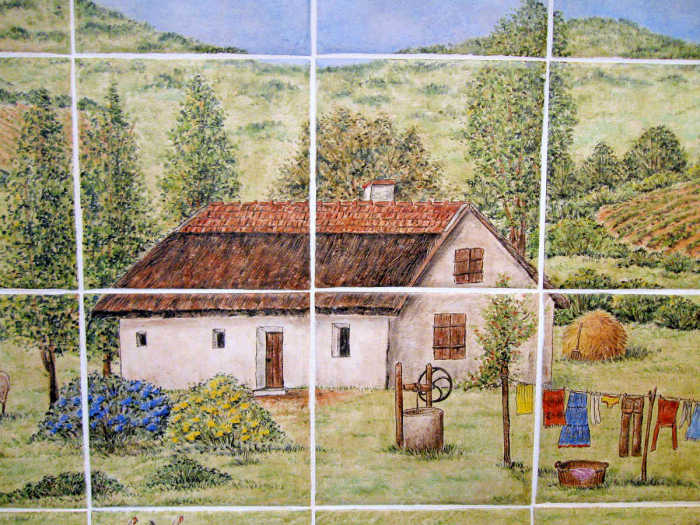 Portrait of the humble farmstead with whitewashed, thatched roof cottage. Hand painted tile art by Julia Sweda.