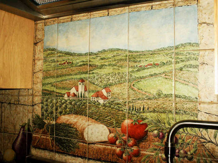 DiPace Kitchen Toscana Vista tile mural backsplash. Closeup 1, rosemary sprigs, fresh bread, tomatoes, olives on window sill, background winery, homes. Artist Julia Sweda.