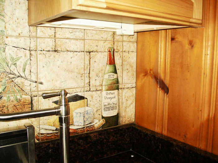 DiPace Kitchen Toscana Vista faux painted right panel, fine Tuscan cheeses, bottle of wine. Artist Julia Sweda.