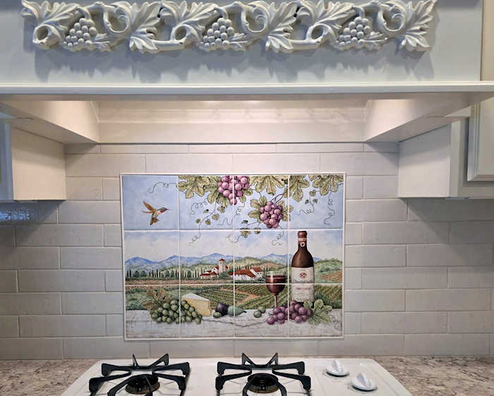 Darla's Montefioralle Chianti Classico, painted kitchen tile mural installed along with subway tiles surround. Artist Julia Sweda.