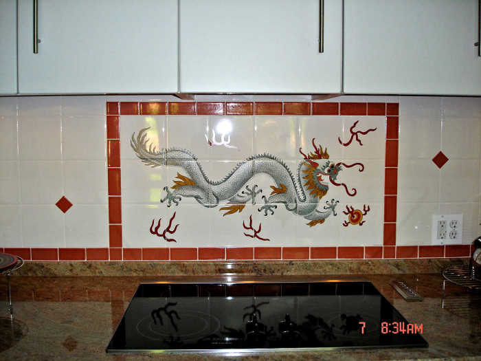 Druk Bhutanese Thunder Dragon installed behind stove with dark red border and accent tiles. Artist Julia Sweda.