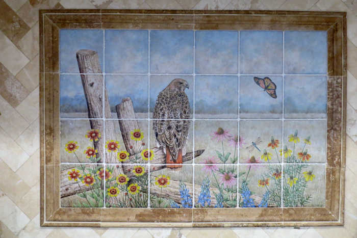 Wild bird portrait of Red-tailed hawk. Installation closeup photo shows a double row of border tiles as a frame. Artist Julia Sweda.